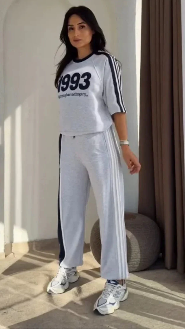 Grey 1993 graphic sweatshirt and matching wide-leg track pants set paired with white chunky sneakers 01
