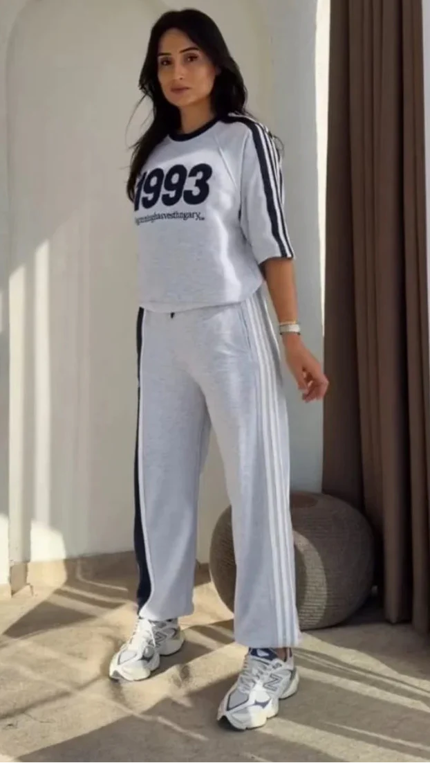 Grey 1993 graphic sweatshirt and matching wide-leg track pants set paired with white chunky sneakers 04