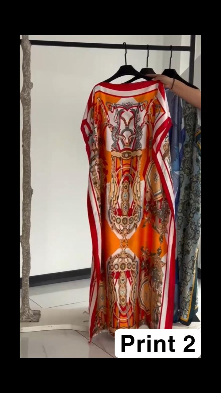 Vibrant multi-colored circular print kaftan with a bright orange border, displayed on a clothing rack 02