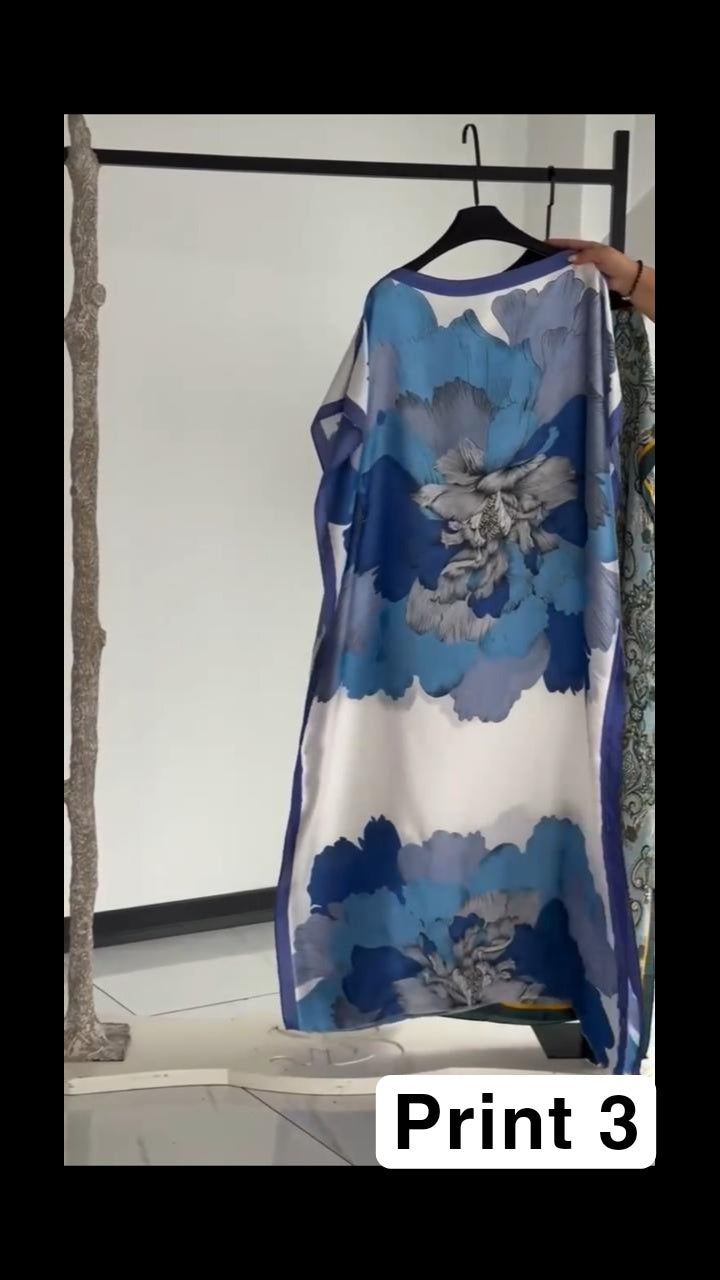 Vibrant multi-colored circular print kaftan with a bright orange border, displayed on a clothing rack 03